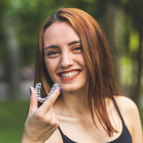 Young Woman Outdoors with Clear Aligners